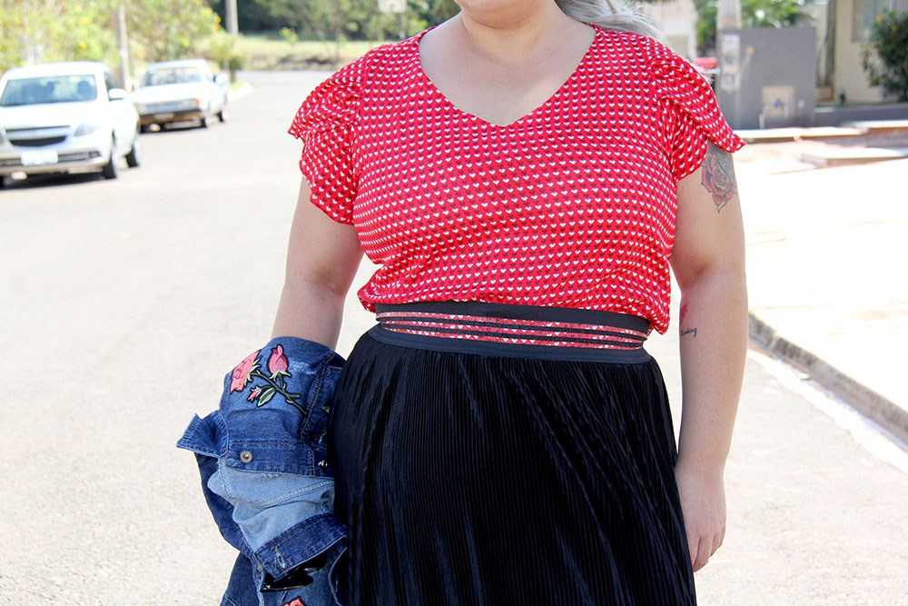 Look do dia plus size com blusa de corações e saia plissada